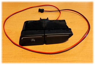 A black switch with a red wire

Description automatically generated